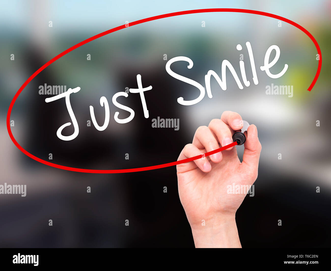 Man main écrit juste sourire grâce au marqueur noir sur l'écran visuel Banque D'Images