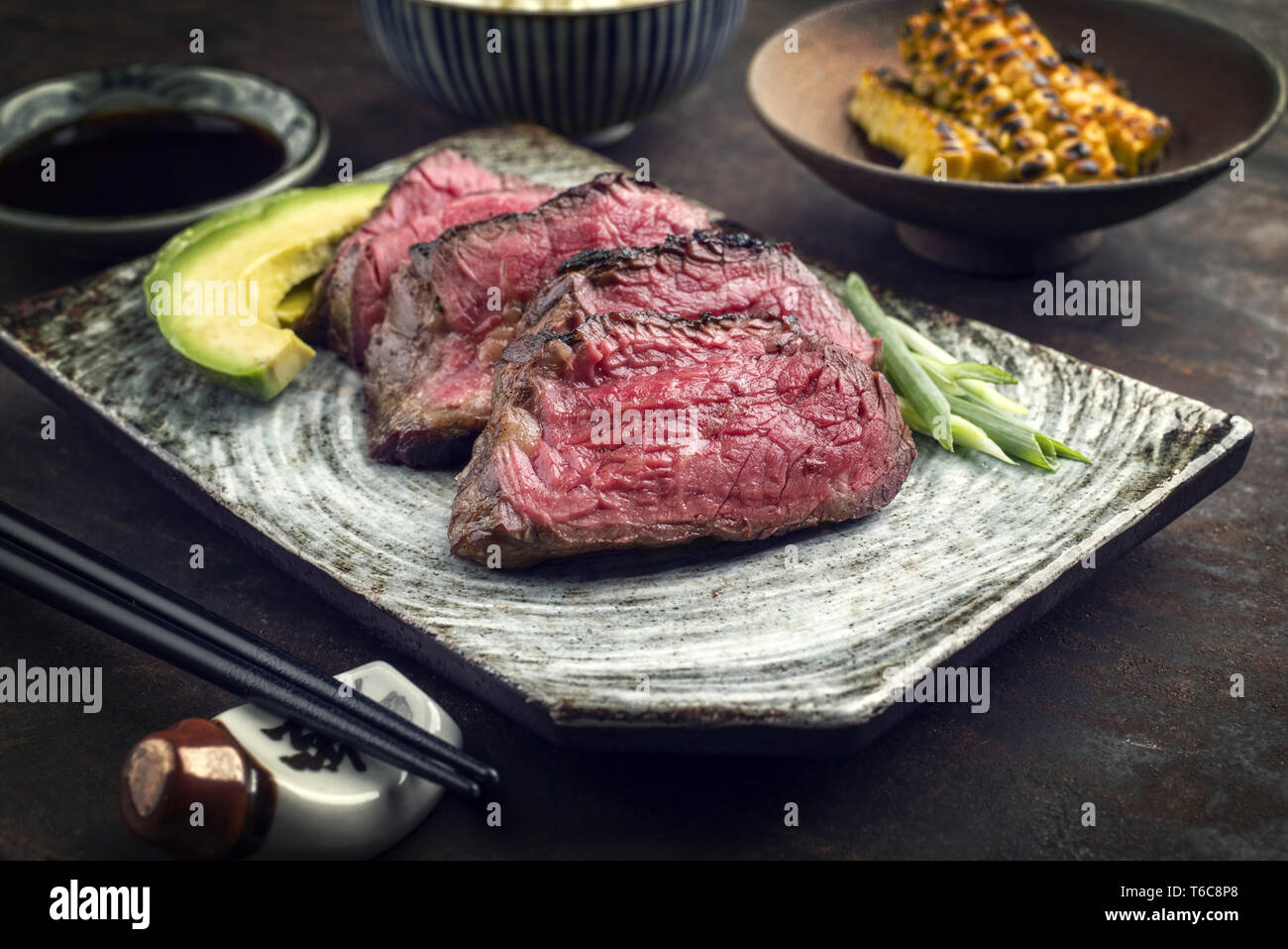 Filet de Bœuf de Kobe japonais avec du riz et de l'avocat comme close-up sur une plaque Banque D'Images