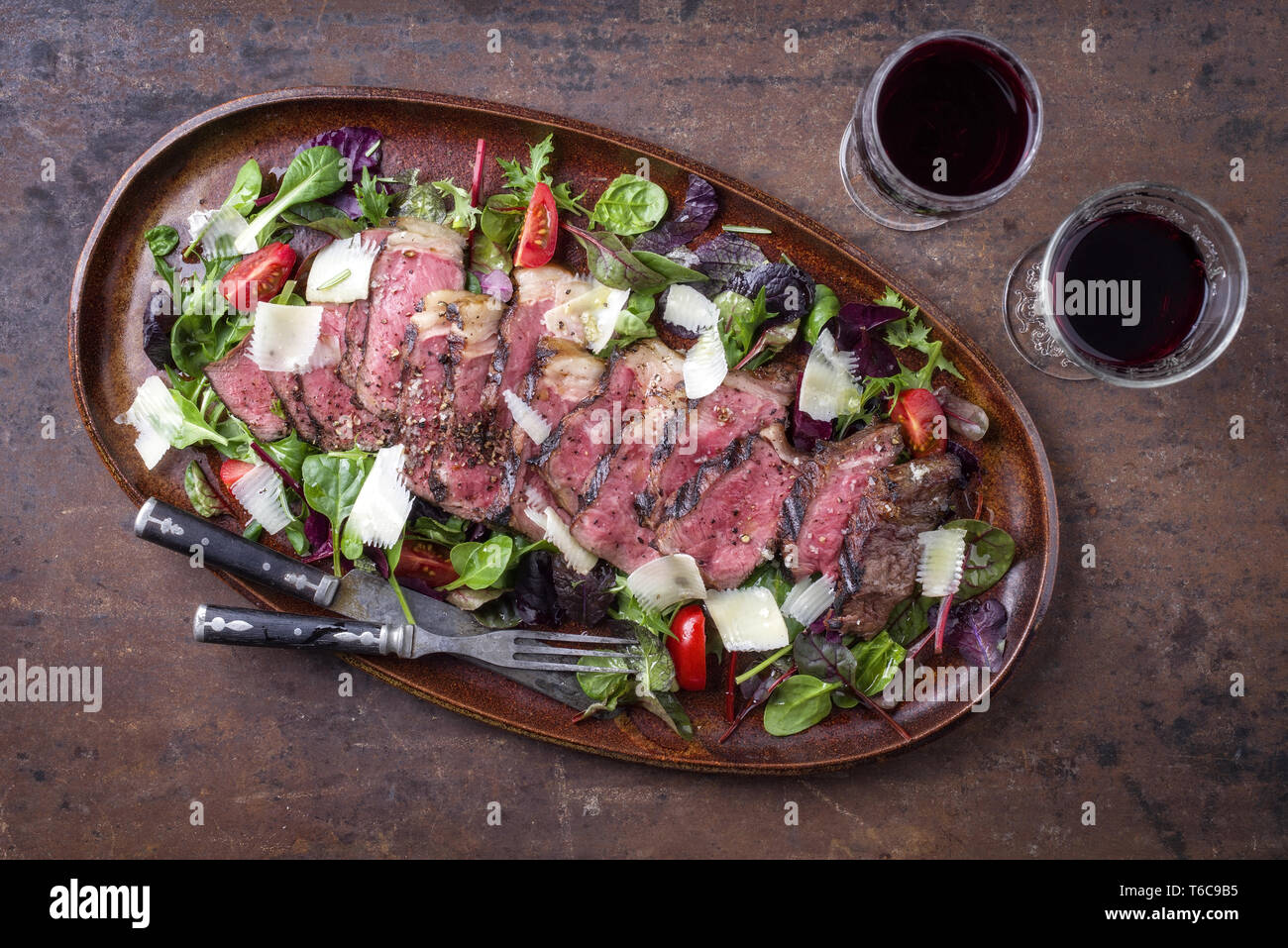 Italien traditionnel steak tagliata de parmesan et salade comme close-up sur une plaque Banque D'Images