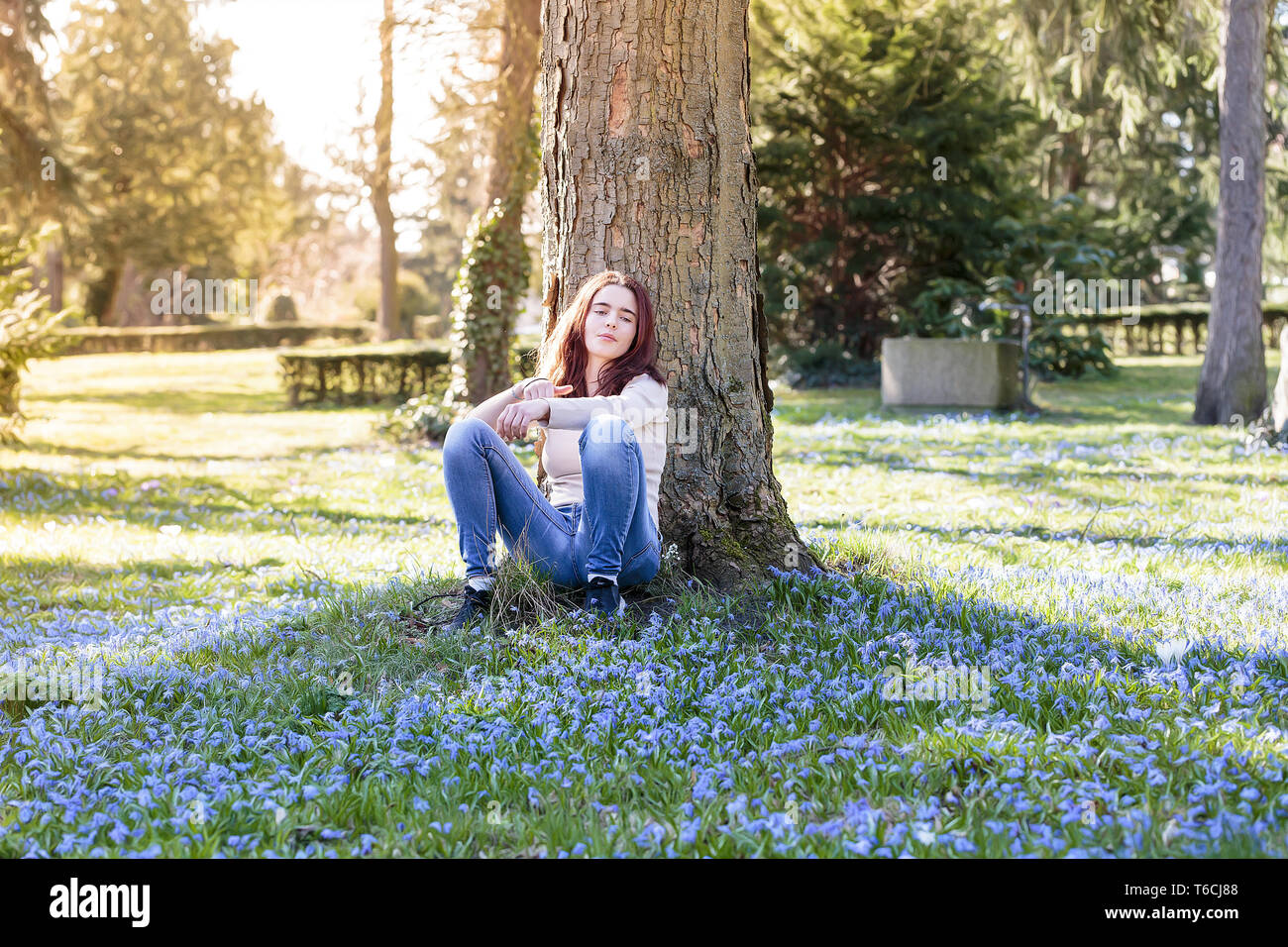 Jeune femme assise sur une prairie de fleurs de printemps Banque D'Images
