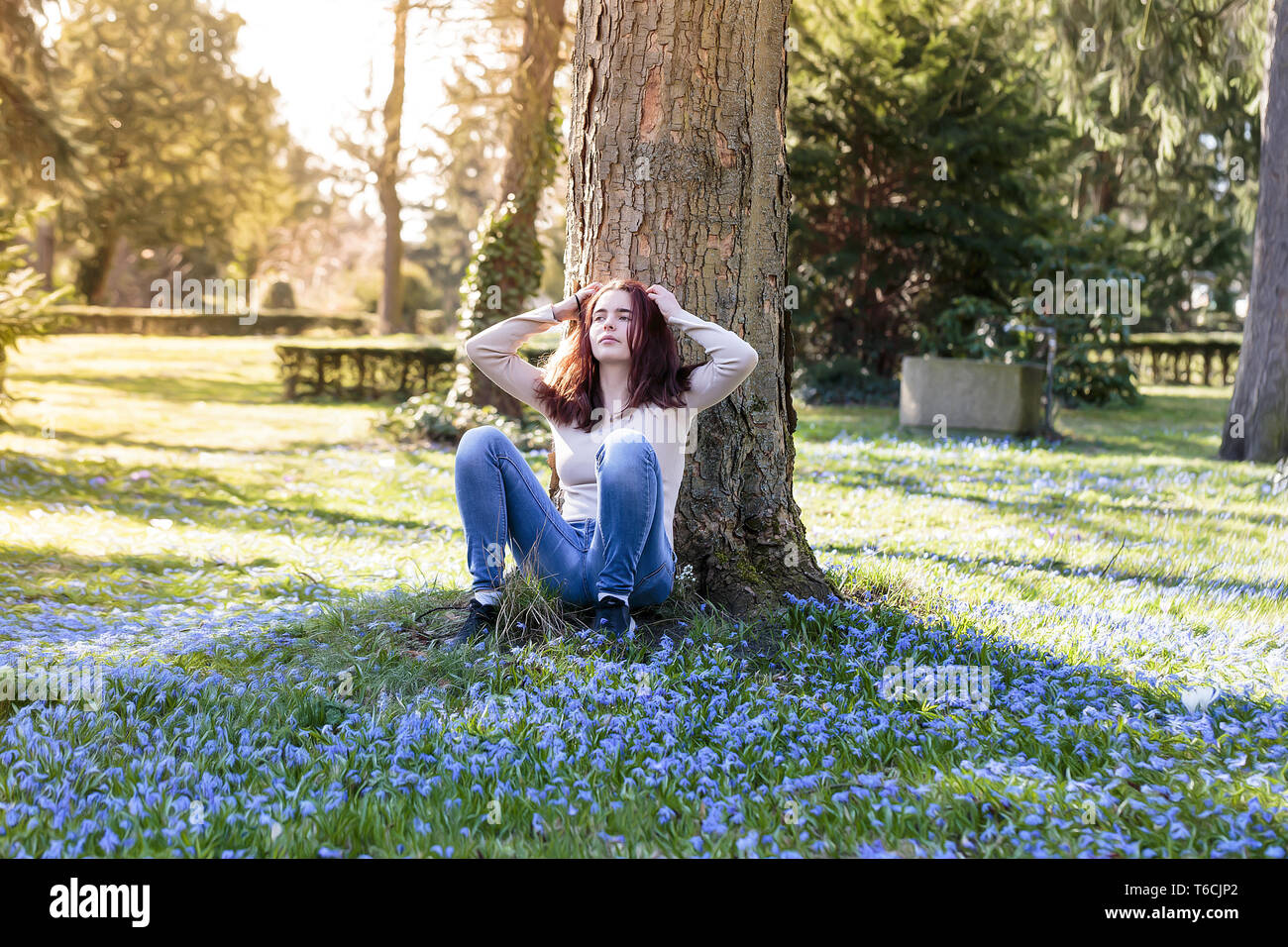 Jeune femme assise sur une prairie de fleurs de printemps Banque D'Images