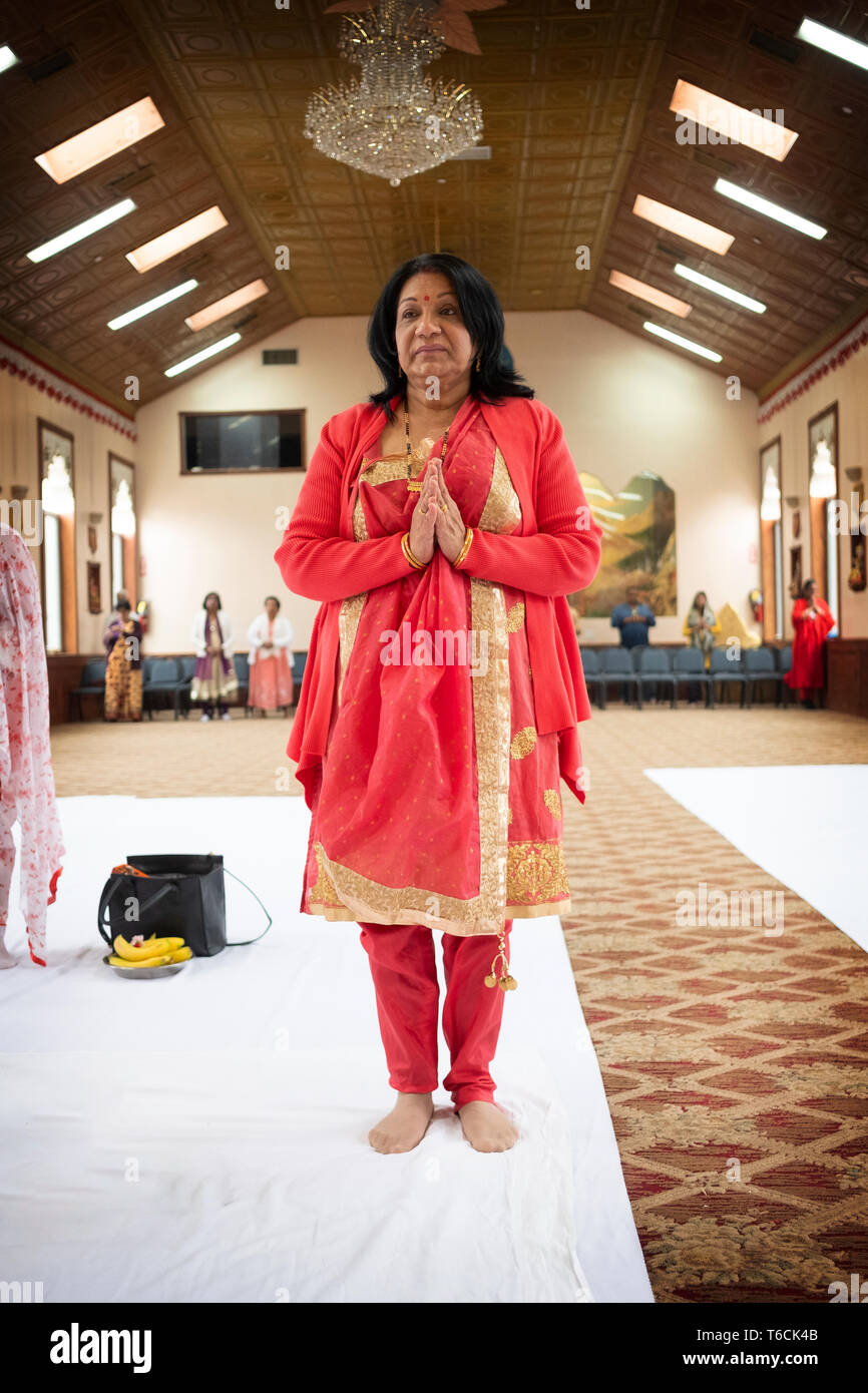 Une jolie femme hindoue d'âge moyen dans un beau sari avec elle les mains jointes dans un temple en Jamaïque, Queens, New York. Banque D'Images