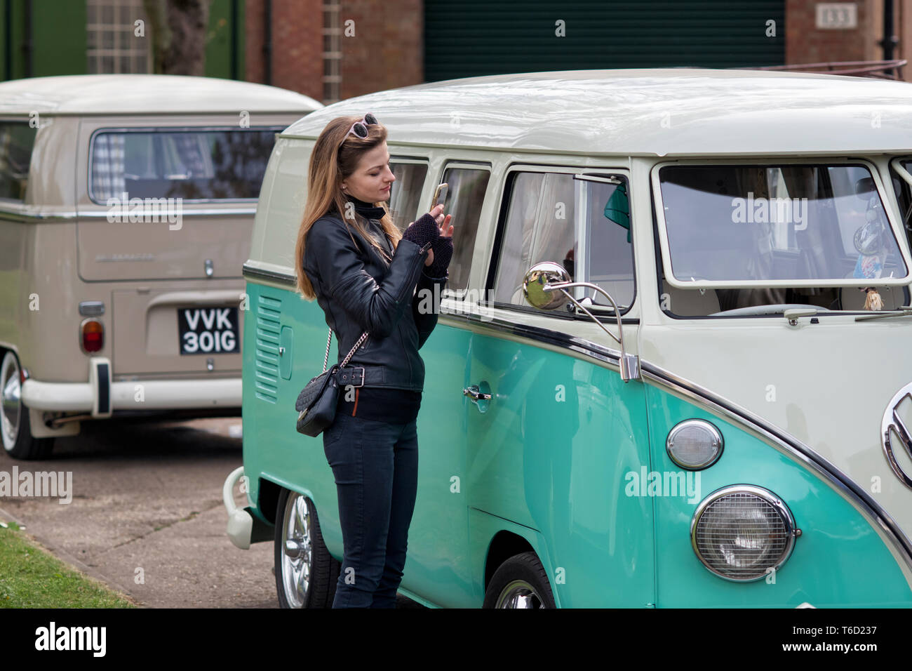 Des photos de femme d'un écran partagé 1966 VW Volkswagen camper van sur son téléphone mobile. Centre du patrimoine mondial de Bicester 'Drive il Day'. Oxfordshire, Angleterre Banque D'Images