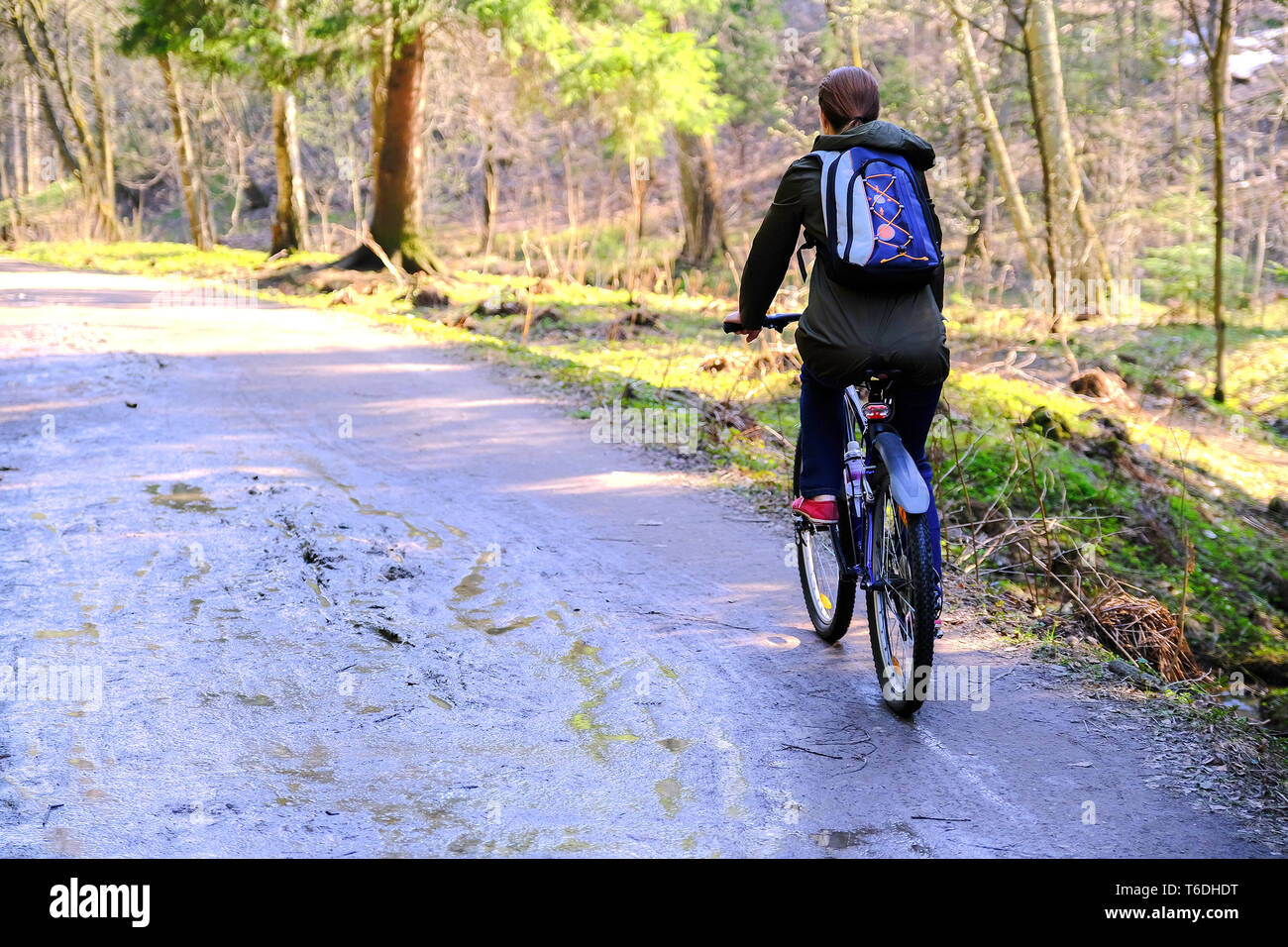 Grande sportive cycliste avec un sac à dos de faire du vélo sur une route forestière Banque D'Images