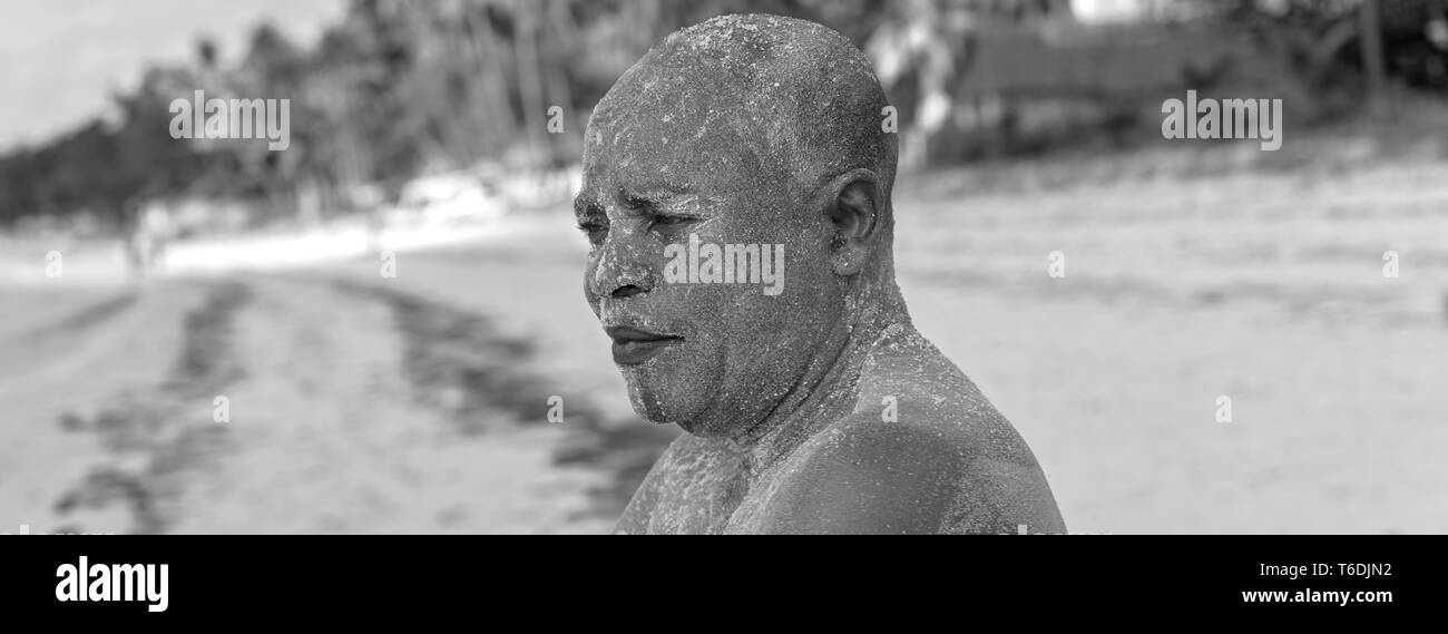 Soins de la peau par le sable corallien le balayage est fait à la plage en Afrique, à améliorer leur beauté par la routine quotidienne. Banque D'Images