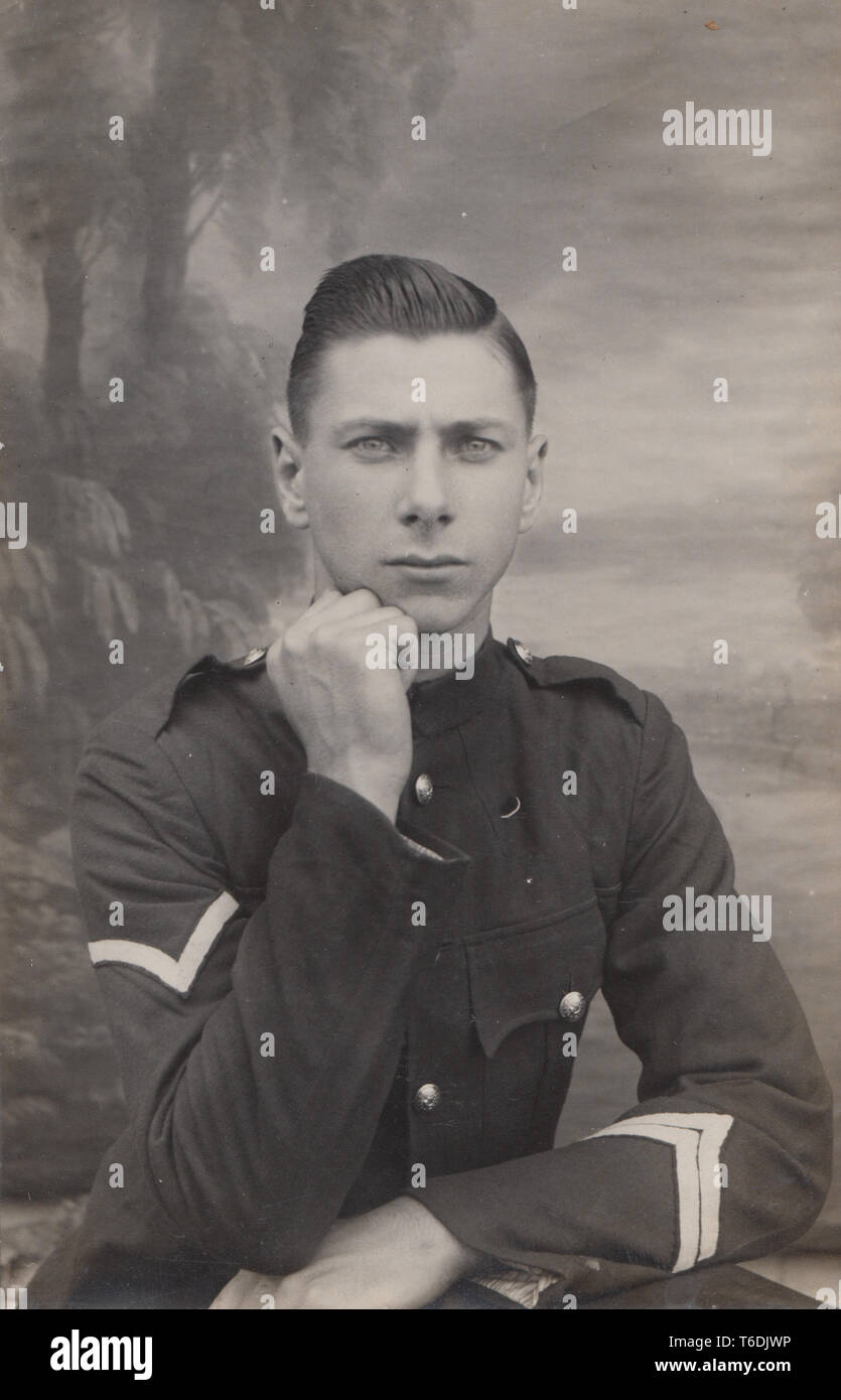 Vintage Portrait photographique Carte postale montrant un jeune homme séduisant élégant portant un uniforme militaire Banque D'Images