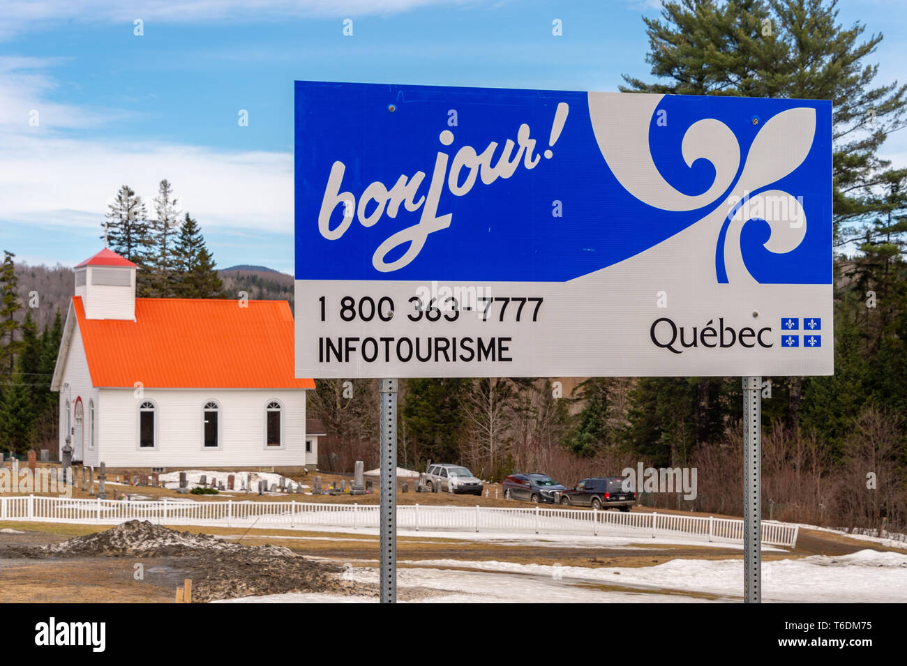 Hereford, QC, Canada - 21 Avril 2019 : Bienvenue au Québec signe en frontière USA/Canada, avec l'église anglicane All Saints en arrière-plan Banque D'Images