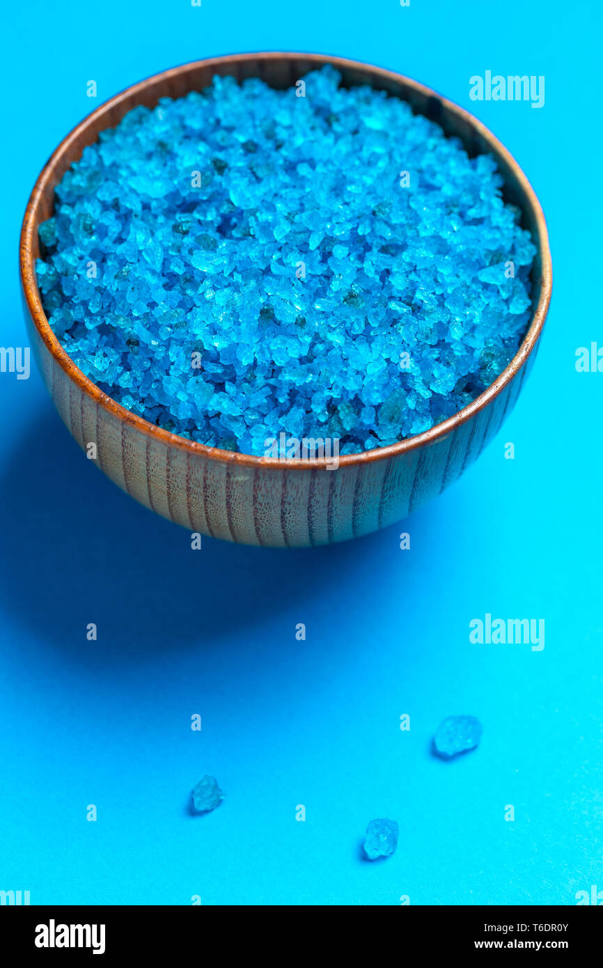Bol avec le sel de bain bleu sur fond bleu Banque D'Images
