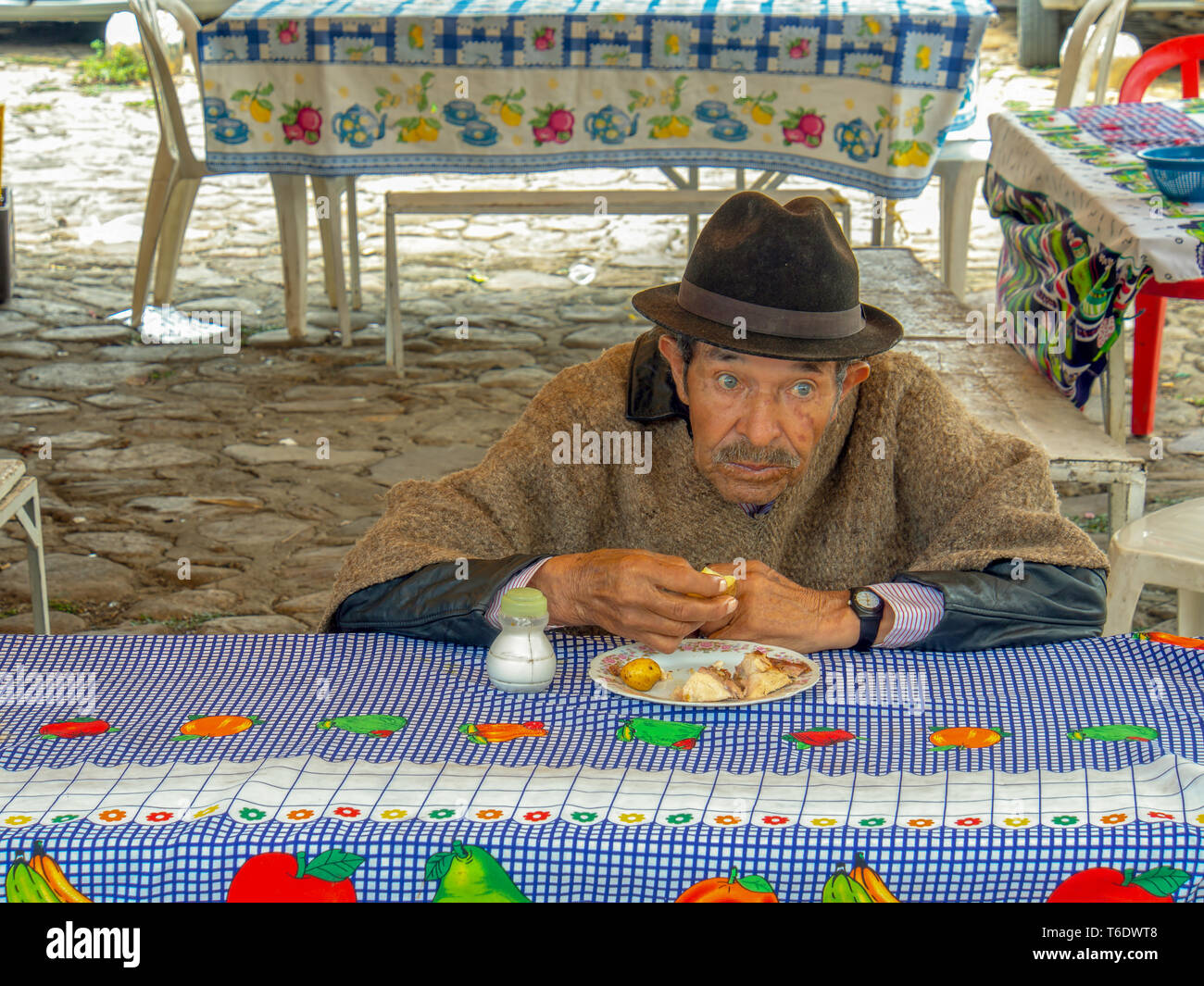 Un ancien agriculteur régional mange son déjeuner dans un restaurant décontracté à l'échelle locale du marché traditionnel de la Villa de Leya, la Colombie. Banque D'Images