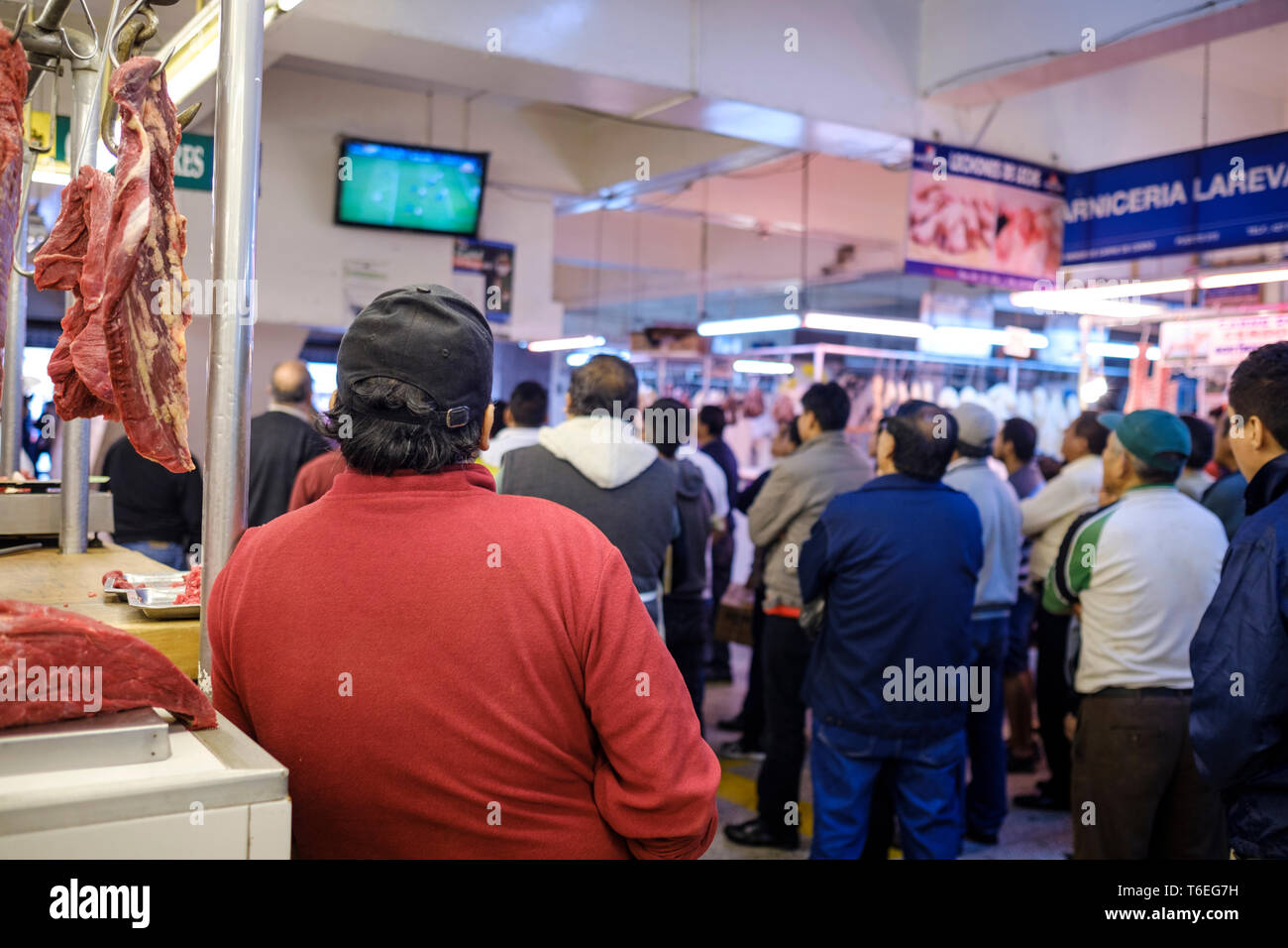 Les gens regarder le football sur un écran de télévision à l'intérieur du Marché Central ou Mercado Central à Lima, Pérou Banque D'Images