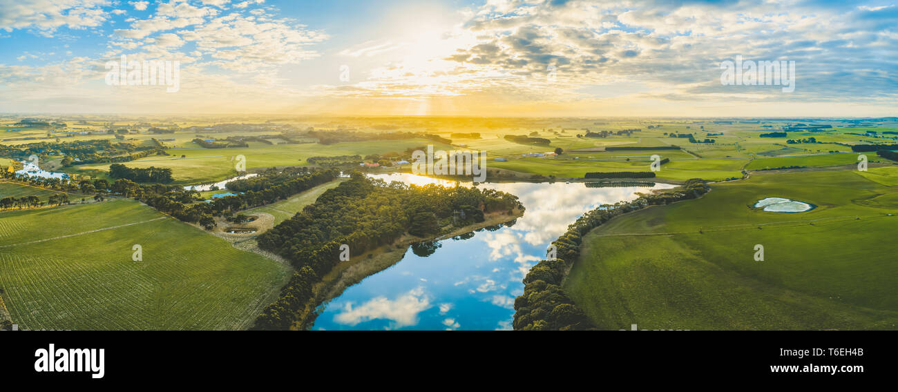 Soleil sur scenic campagne australienne herbages et pâturages en passant par la rivière - panorama aérien Banque D'Images