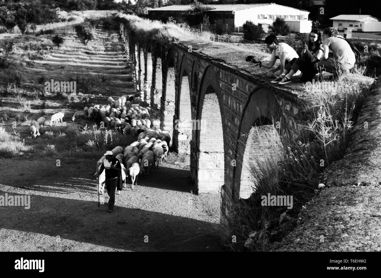 Skopje, Macédoine - 25 août 2017, les jeunes touristes d'explorer un ancien aqueduc et photographier un berger qui passe sous eux. Banque D'Images