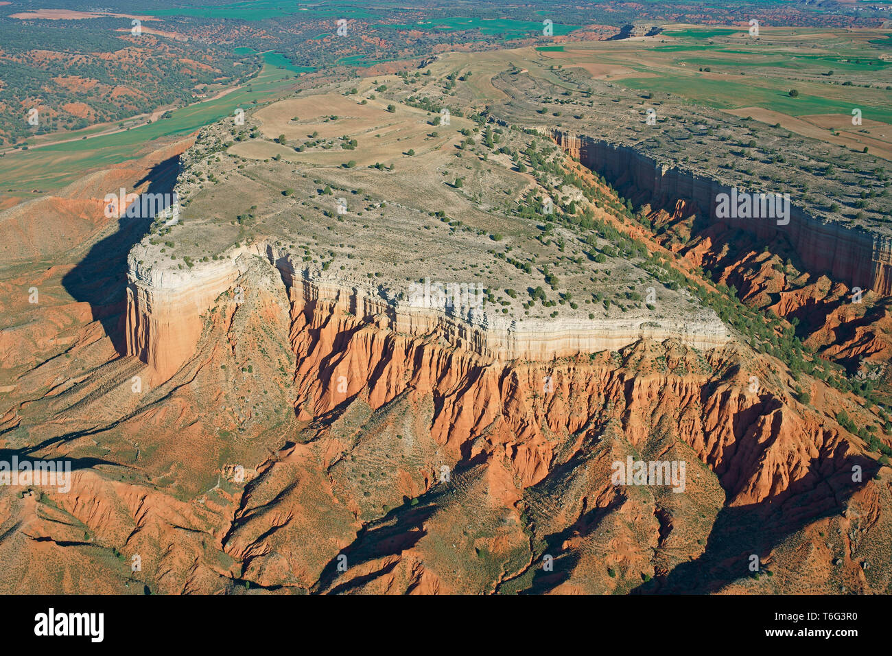 VUE AÉRIENNE. Mesa semi-aride avec ses falaises de strates multicolores. Cañon Rojo (aussi connu sous le nom de Rambla de Barrachina), Teruel, Aragon, Espagne. Banque D'Images