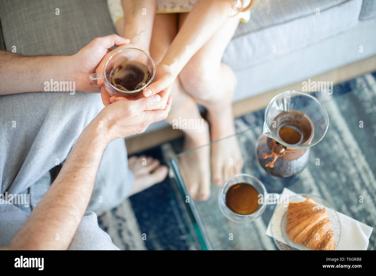 Un couple holding tasse de café ensemble : matin idéal à la maison. Pas de visages sur la photo. Banque D'Images