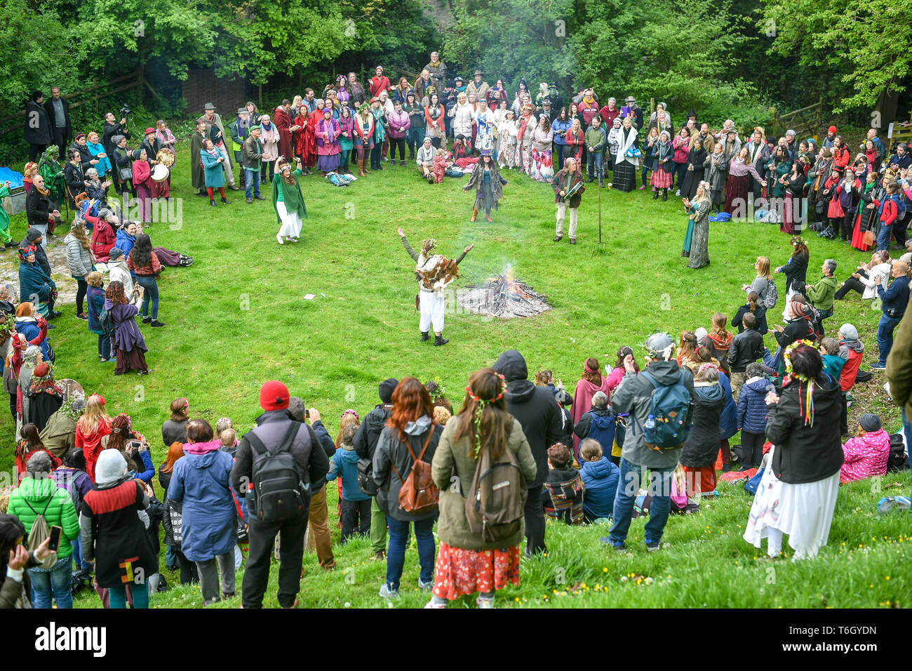 Foules entourent un feu pendant les fêtes de Beltane à Glastonbury Chalice Well, où les gens se rassemblent pour observer une interprétation moderne de l'antique fertilité païenne celtique sacre du printemps. Banque D'Images