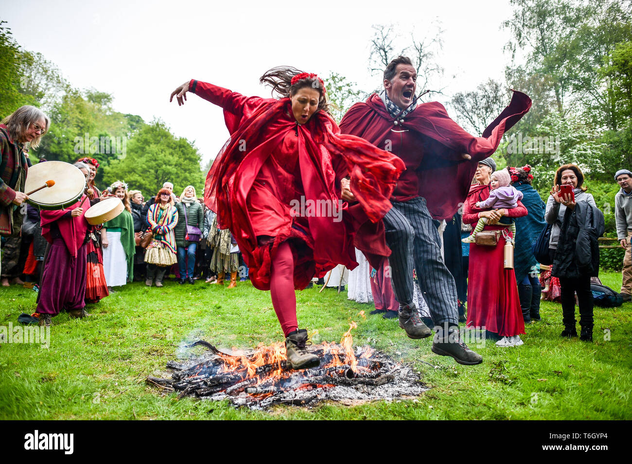 Un couple sur le feu pendant les fêtes de Beltane à Glastonbury Chalice Well, où les gens se rassemblent pour observer une interprétation moderne de l'antique fertilité païenne celtique sacre du printemps. Banque D'Images