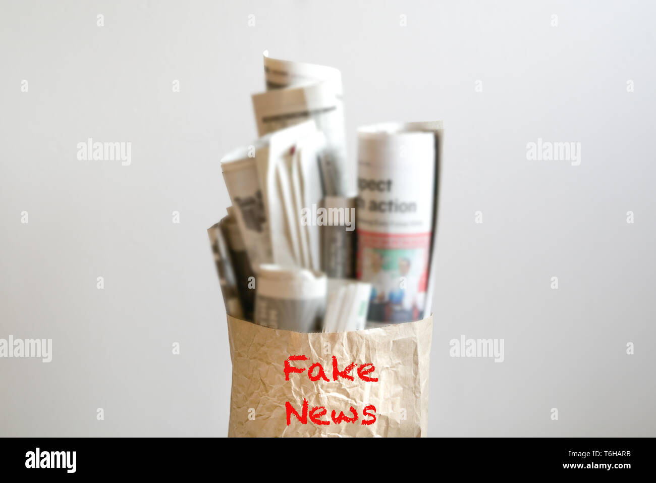 Fake news concept - mot 'Fake News' sur sac en papier rempli de journaux Banque D'Images