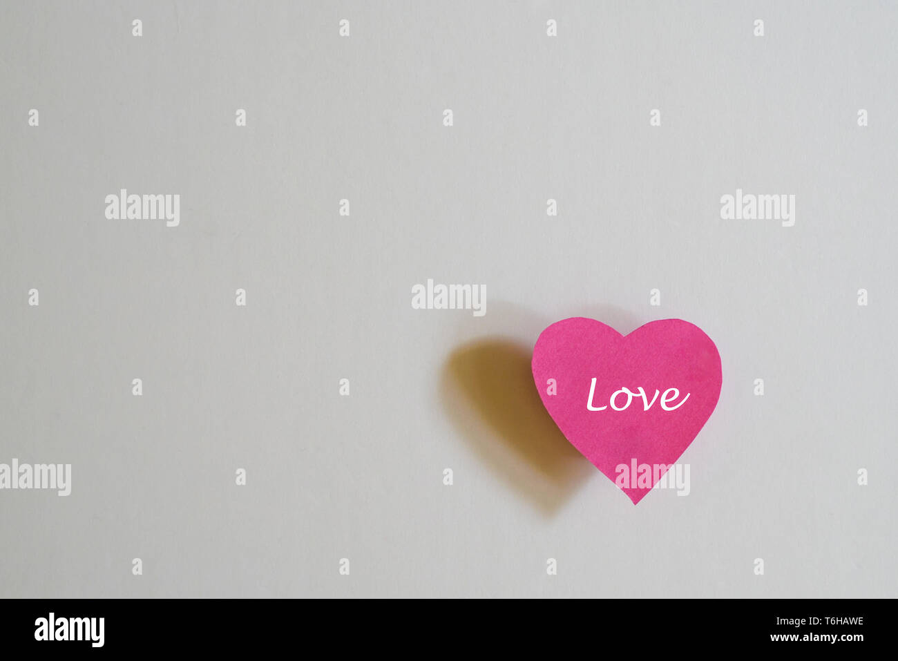 Concept d'amour : papier forme de coeur et l'ombre sur fond blanc et copy space Banque D'Images