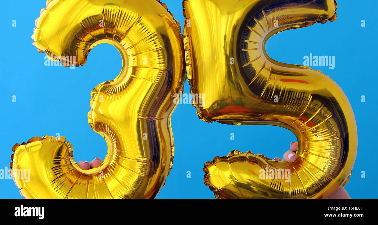 Numéro de feuille d'or 35 ballon célébration sur fond bleu Banque D'Images