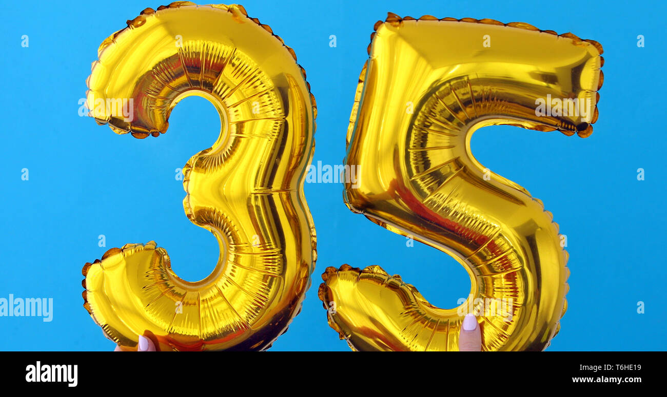 Numéro de feuille d'or 35 ballon célébration sur fond bleu Banque D'Images