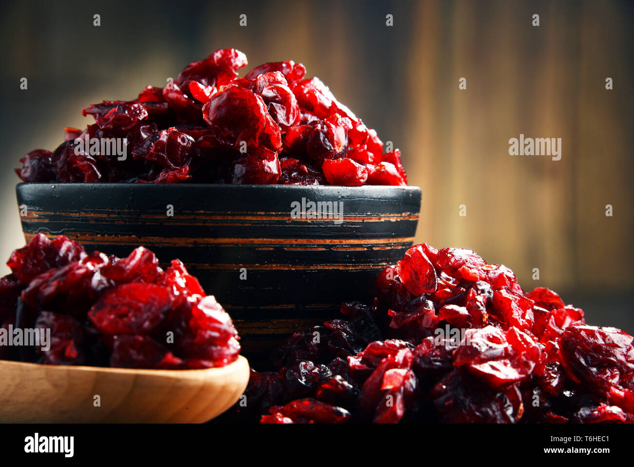 La composition avec bol de canneberges séchées sur table en bois. Banque D'Images
