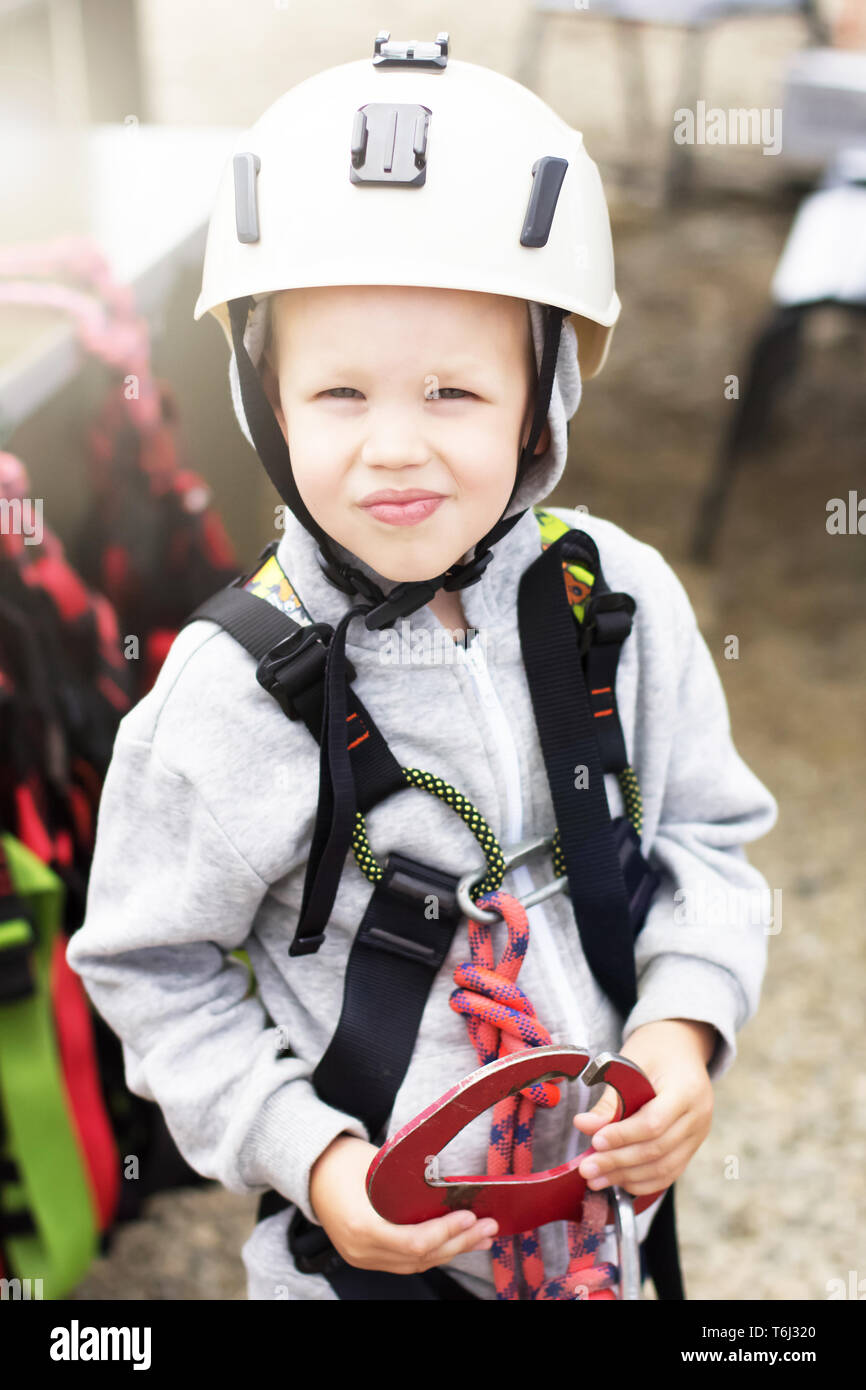 Caucasian boy in un casque d'escalade avant le début du passage d'obstacles Banque D'Images