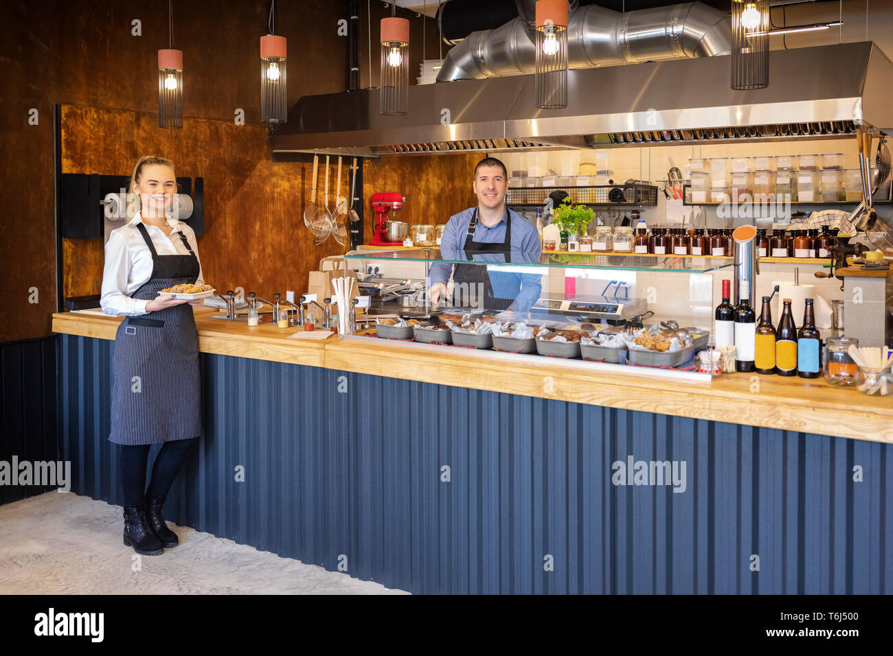 Le service au comptoir au bistro moderne avec des serveurs souriants servant de la nourriture Banque D'Images