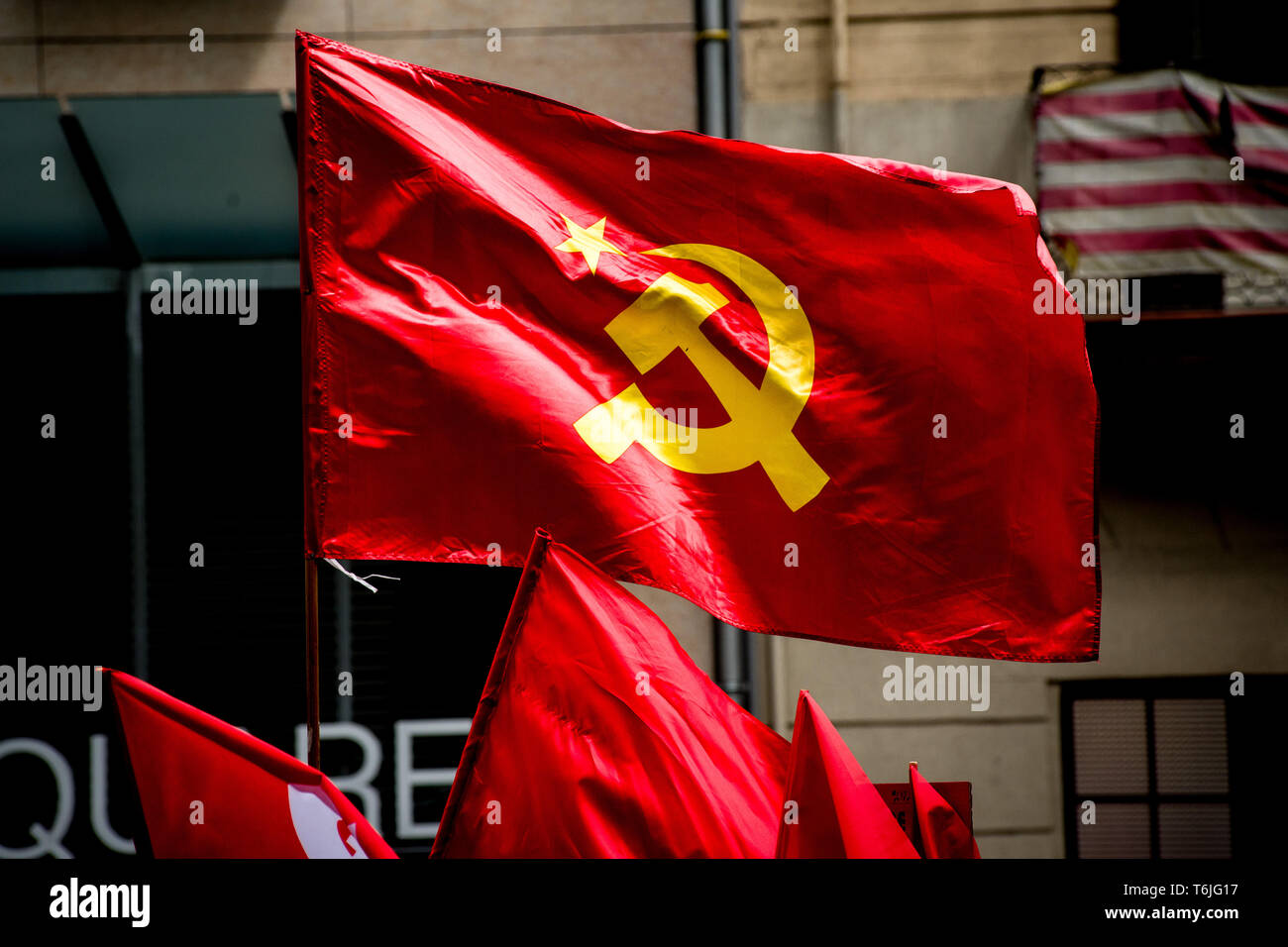 Drapeaux communistes en tant que travailleurs mars lors de mai dans le centre de Barcelone. Banque D'Images