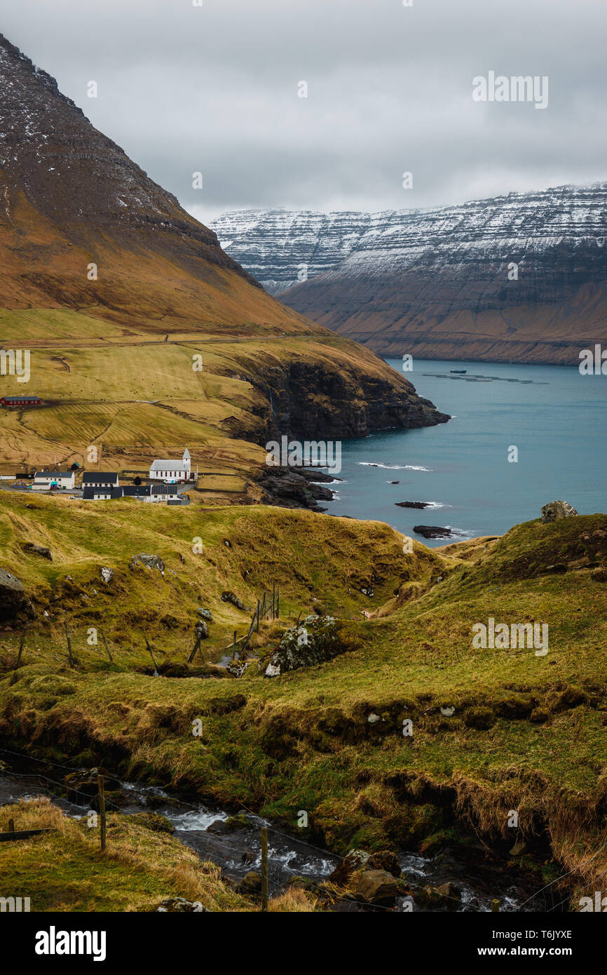Vue de la Kap Enniberg vers le petit village, Viðareiði Viðareiði kirkja, son fjord et montagnes neige-couvertes (îles Féroé, Danemark, Europe) Banque D'Images