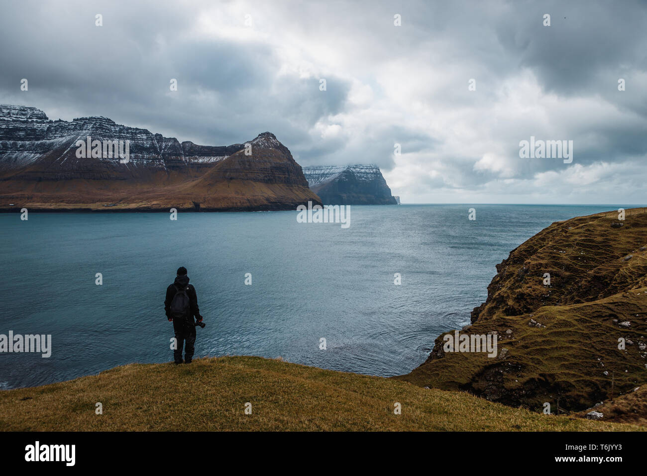 Photographe en profitant de la vue de l'île de Kunoy et Kalsoy vus de Kap Enniberg dans Viðareiði (îles Féroé, Danemark, Europe) Banque D'Images