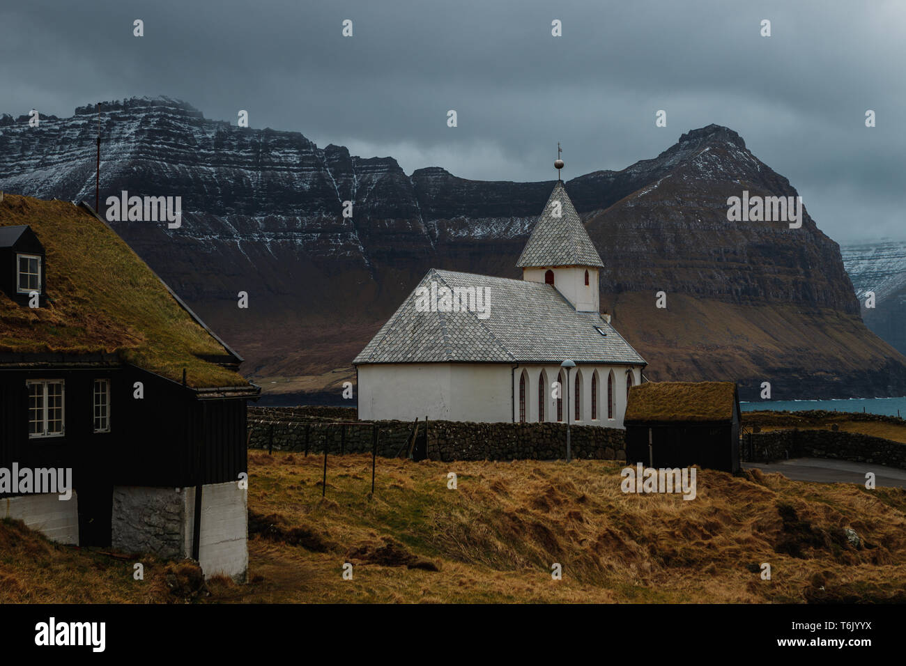 Vue sur l'église de Viðareiði Viðareiði Kirkja () avec moody ciel nuageux, brouillard et montagnes neige-couvertes (îles Féroé, Danemark, Europe) Banque D'Images