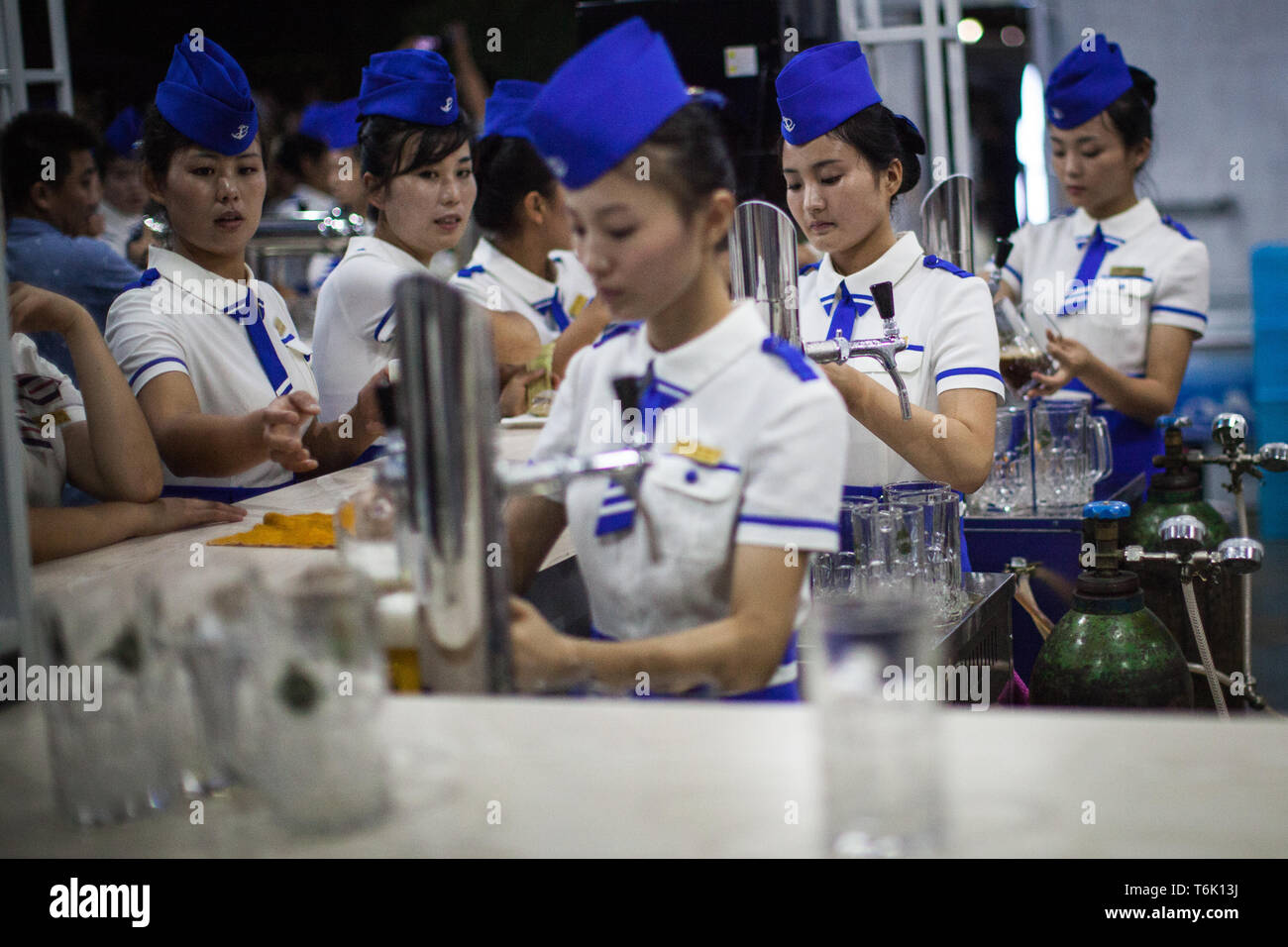 Les serveuses au festival de la bière de Pyongyang pintes servir pour les habitants et les touristes. Banque D'Images