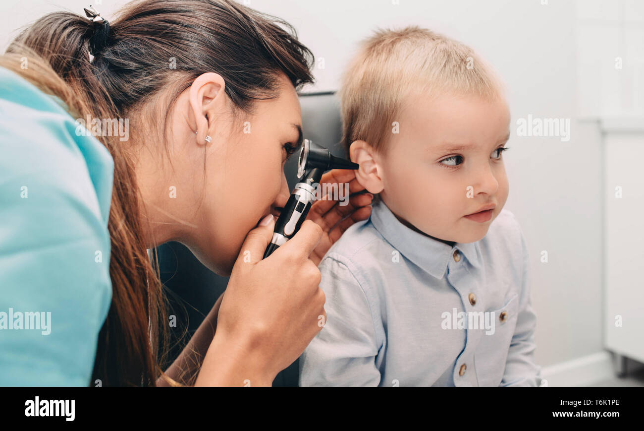ENT médecin faisant un examen de l'oreille avec otoscope pour petit garçon Banque D'Images