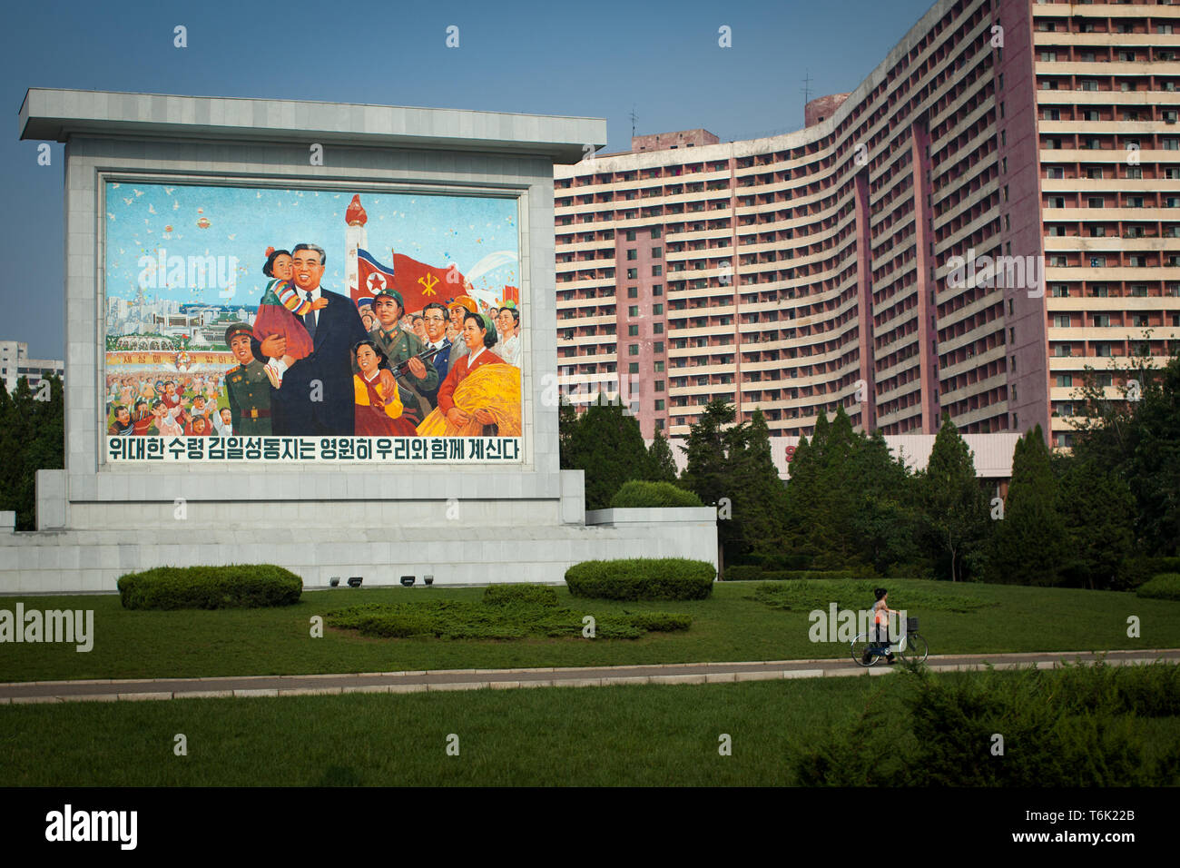 Les plaques de rue d'encourager le patriotisme en face d'un grand immeuble à Pyongyang. Banque D'Images