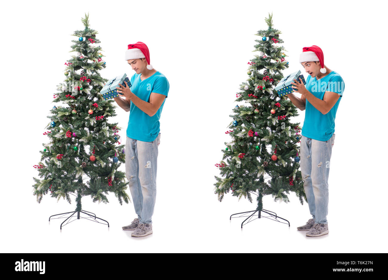 Jeune homme decorating Christmas Tree isolated on white Banque D'Images