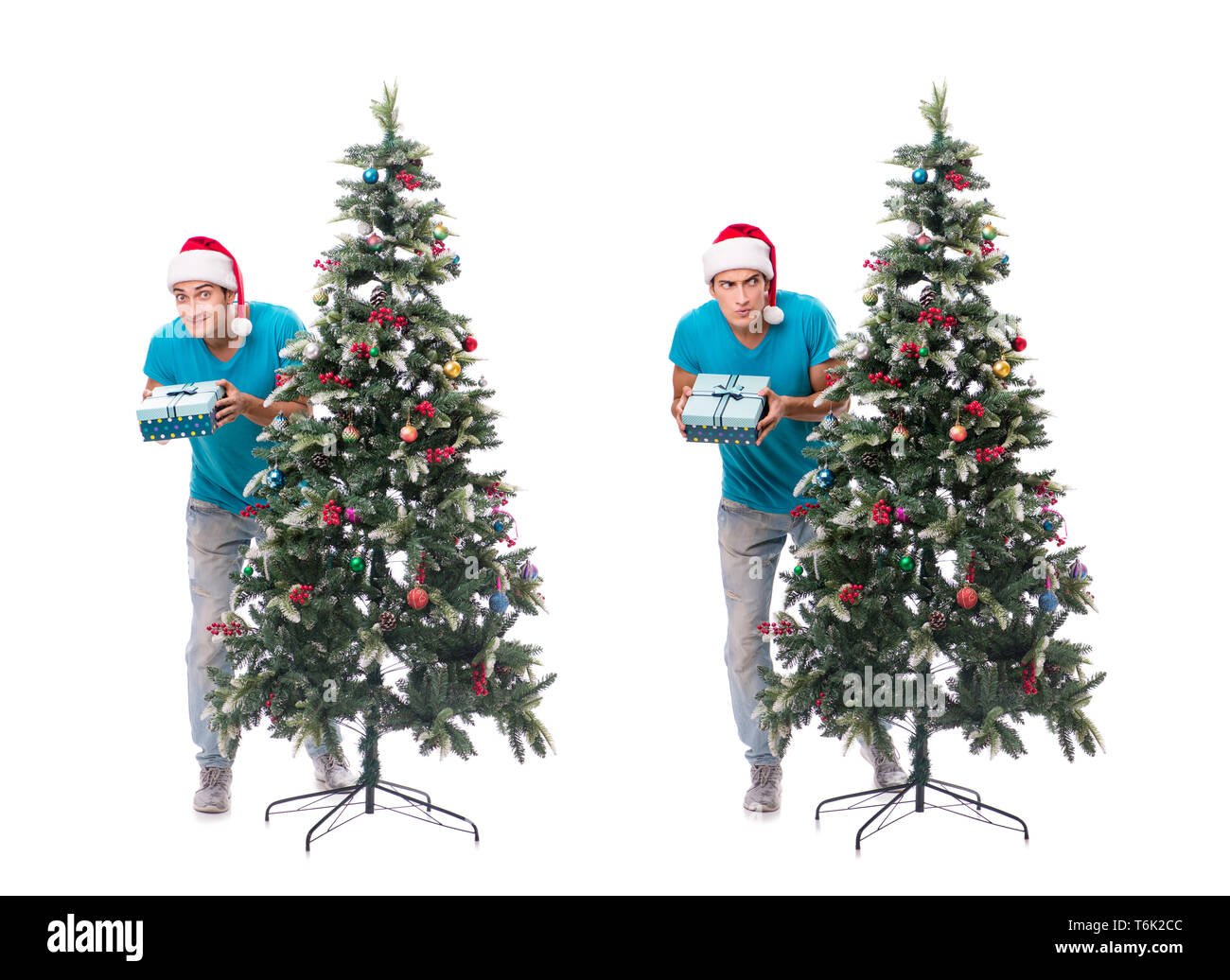 Jeune homme decorating Christmas Tree isolated on white Banque D'Images