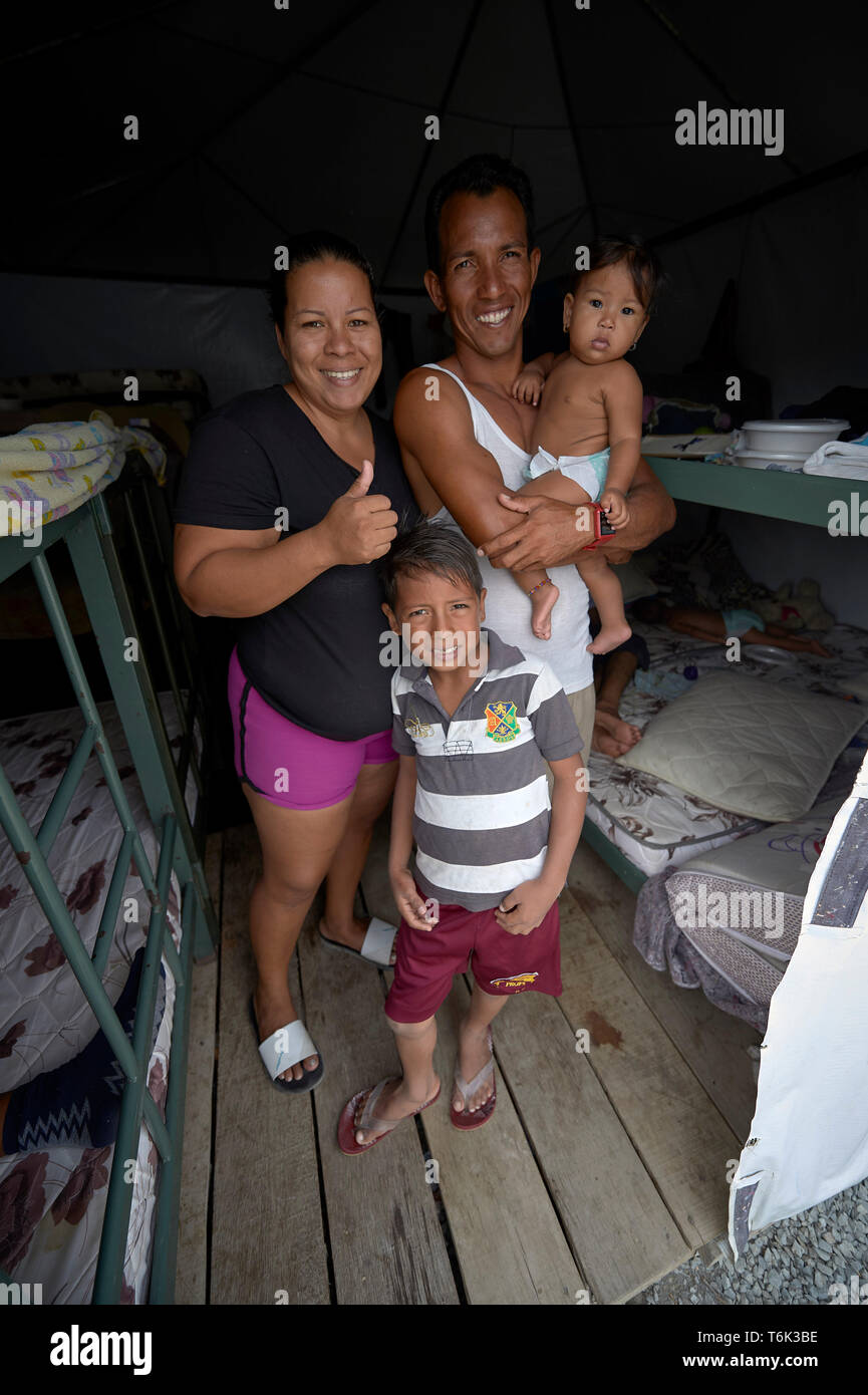 Une famille de réfugiés pose dans leur refuge dans un camp militaire à Pacaraima, une ville brésilienne sur la frontière avec le Venezuela. Banque D'Images