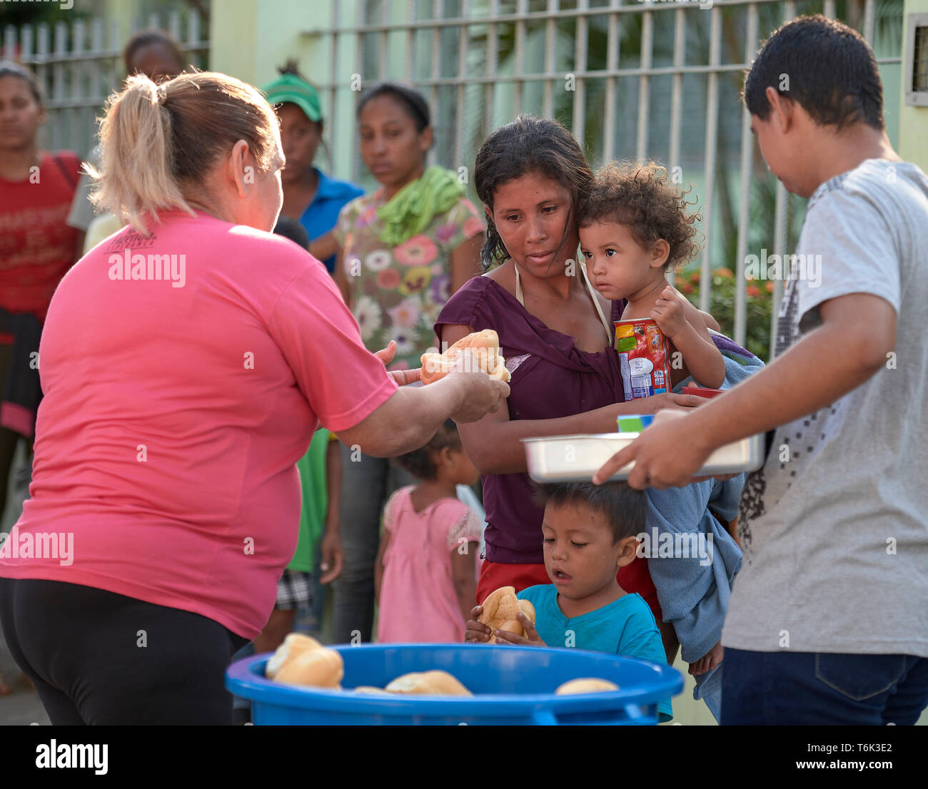 Une famille de réfugiés vénézuélienne reçoit la nourriture à Boa Vista, au Brésil, dans le cadre d'un programme d'alimentation d'urgence géré par les Sœurs Missionnaires de la Consolata. Banque D'Images