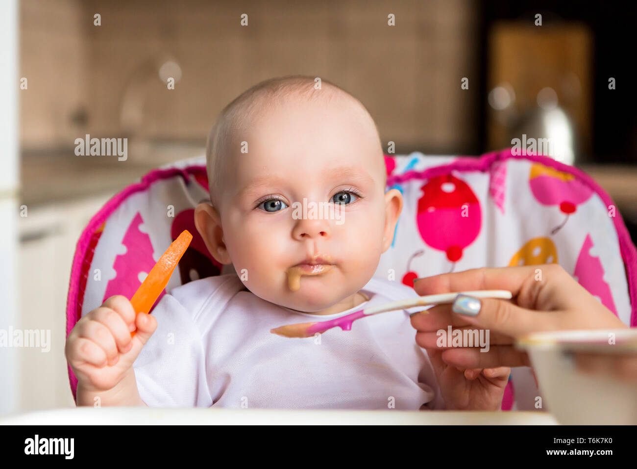 Bébé A 8 Mois Et Mange De Manière Indépendante.le Premier Bébé De Lure.le  Bébé Aux Yeux Bleus Ne Veut Pas Manger De Purée De Légumes.mom Rss À Partir  D'un Petit Enfant Photo