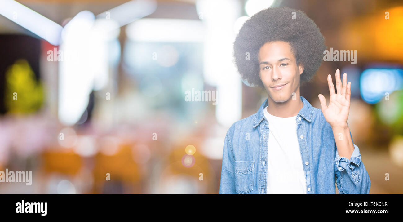 Young african american man avec suppression des cheveux afro disant bonjour heureux et souriant, aimable geste de bienvenue Banque D'Images