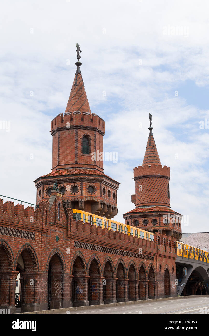 Jaune vieux train de métro (U-Bahn) traversant le célèbre Pont Oberbaum (Oberbaumbrucke) à Berlin, Allemagne. Banque D'Images