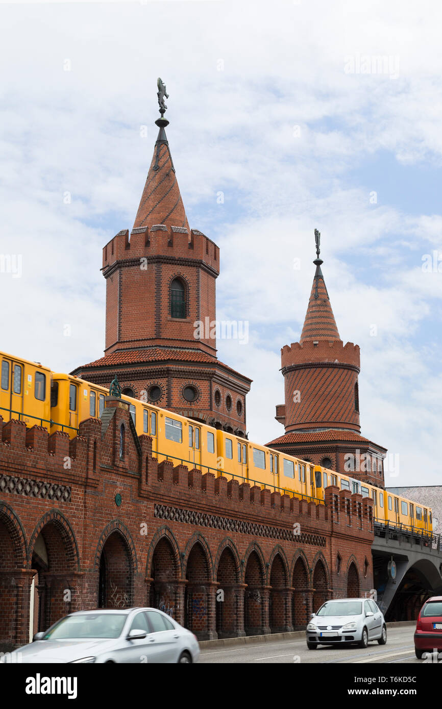 Jaune vieux train de métro (U-Bahn) traversant le célèbre Pont Oberbaum (Oberbaumbrucke) à Berlin, Allemagne. Banque D'Images