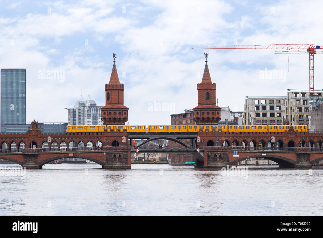 Jaune vieux train de métro (U-Bahn) traversant le célèbre Pont Oberbaum (Oberbaumbrucke) sur la rivière Spree à Berlin, Allemagne. Banque D'Images