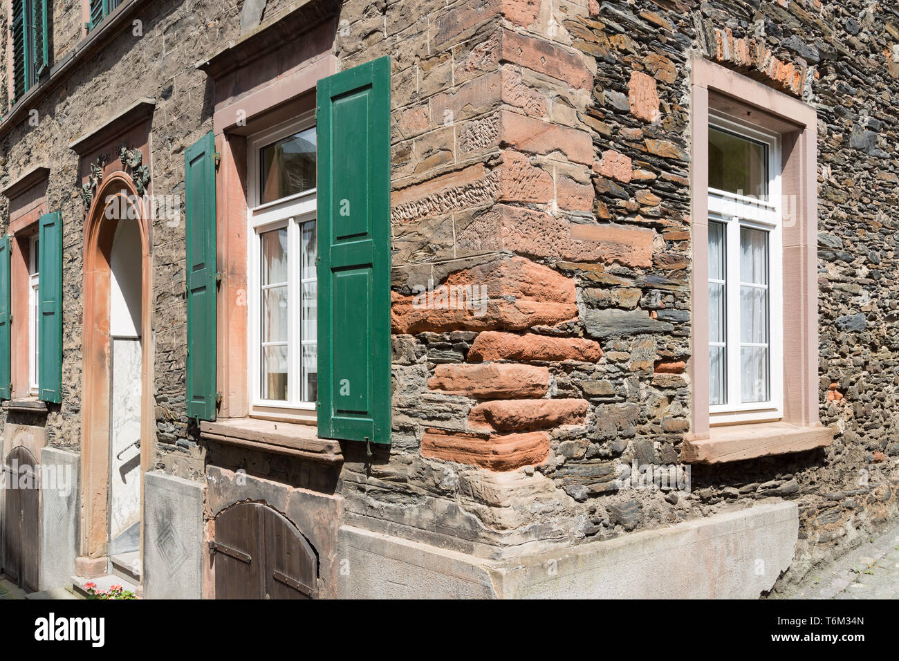 Façade d'une vieille maison en pierre avec des volets en bois Banque D'Images