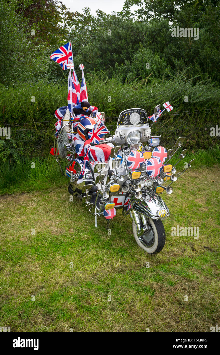 Une période années 60 Vespa scooter décoré de drapeaux Union Jack et chrome miroirs. Banque D'Images