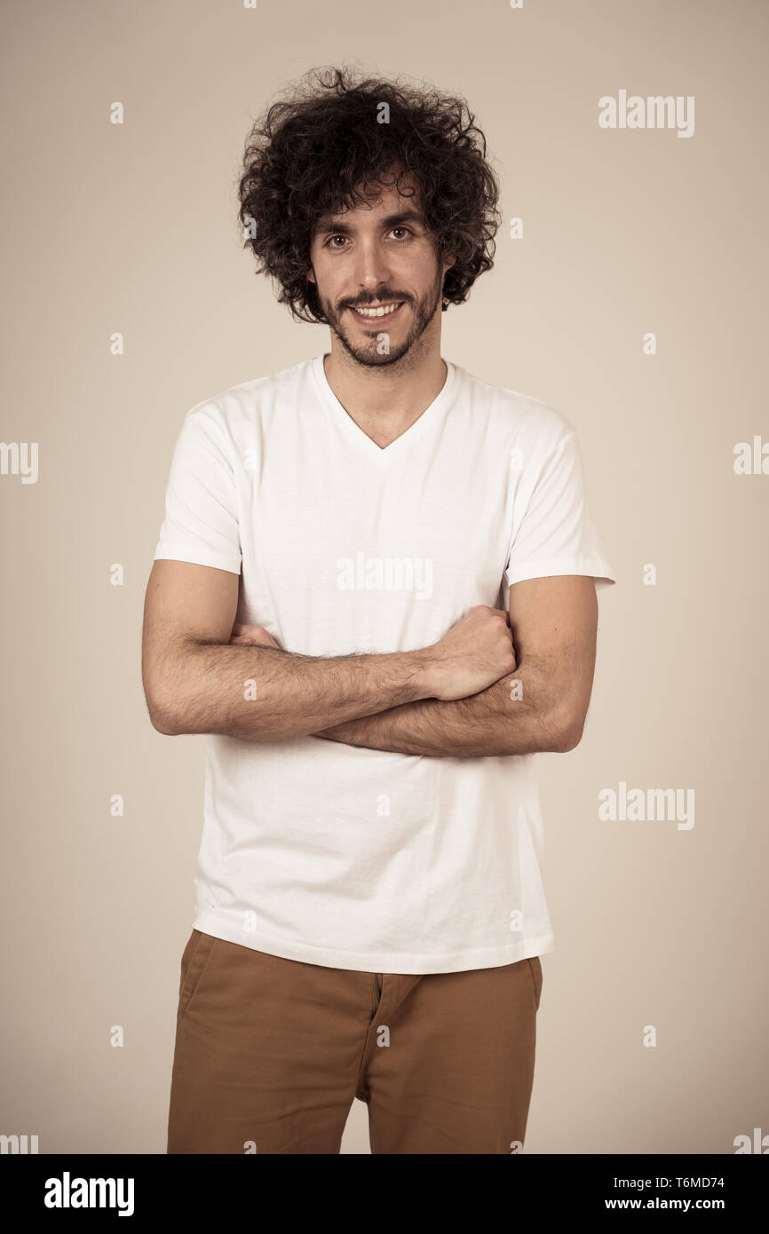 Studio shot of young male millénaire avec l'ours et le grand sourire de cheveux et de faire drôle et gestes amicaux. Isolé sur fond neutre. Banque D'Images