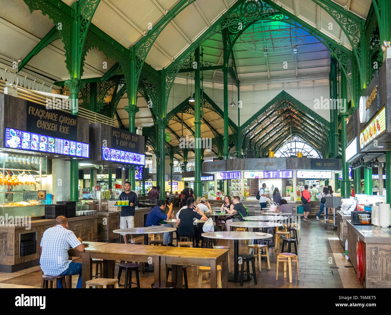 Treillage en fonte peint en vert, et les convives assis à des tables Lau Pa Sat Hawker Food Markets au centre-ville de Singapour. Banque D'Images