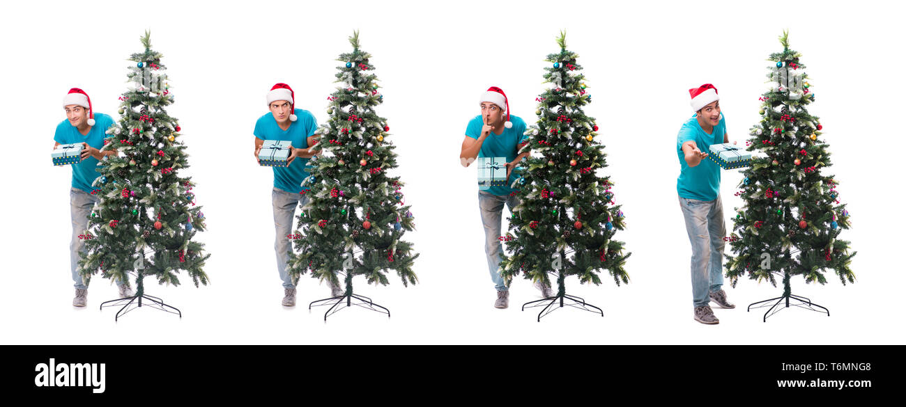 Jeune homme decorating Christmas Tree isolated on white Banque D'Images