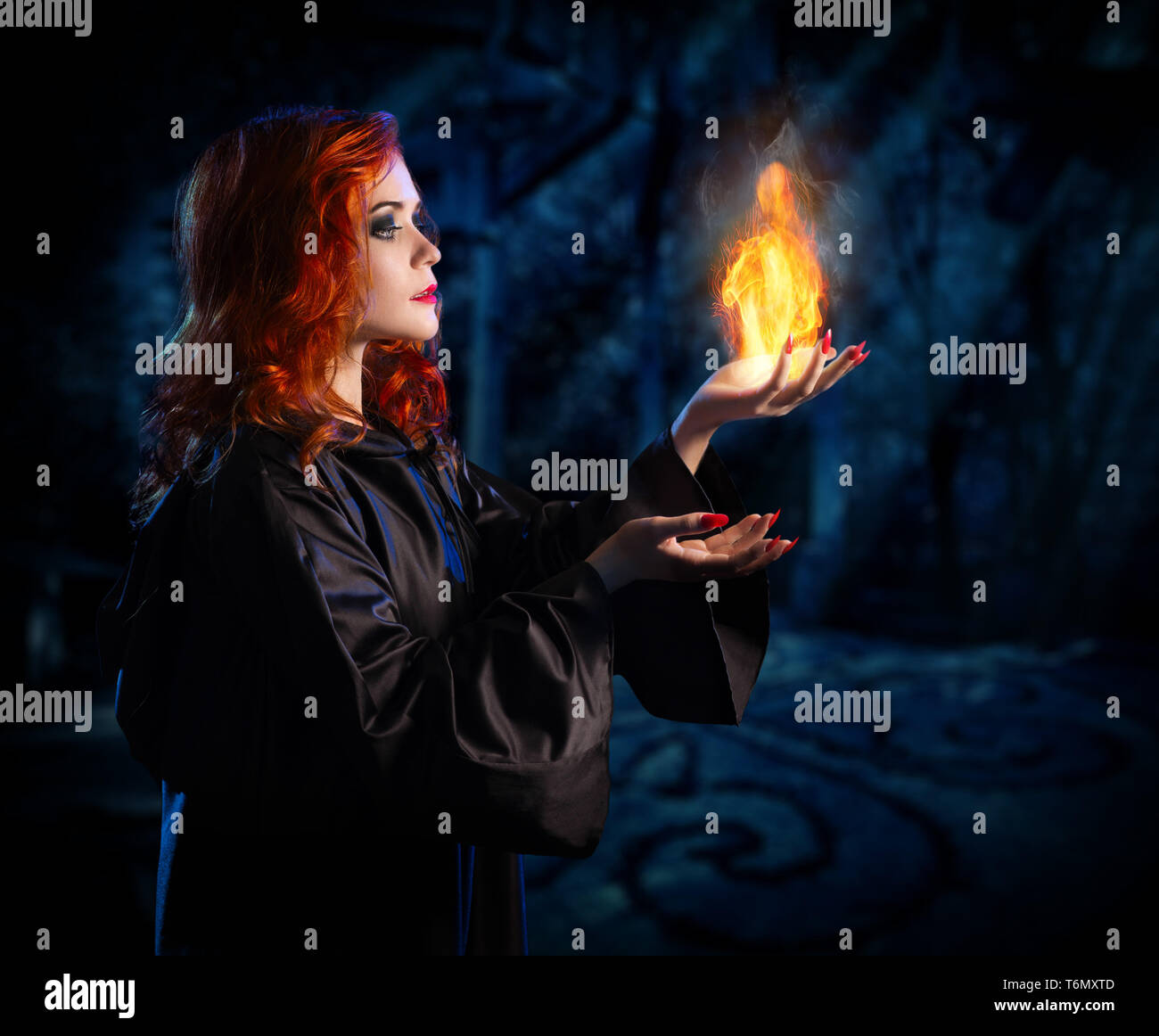 Jeune sorcière dans la forêt la nuit Banque D'Images