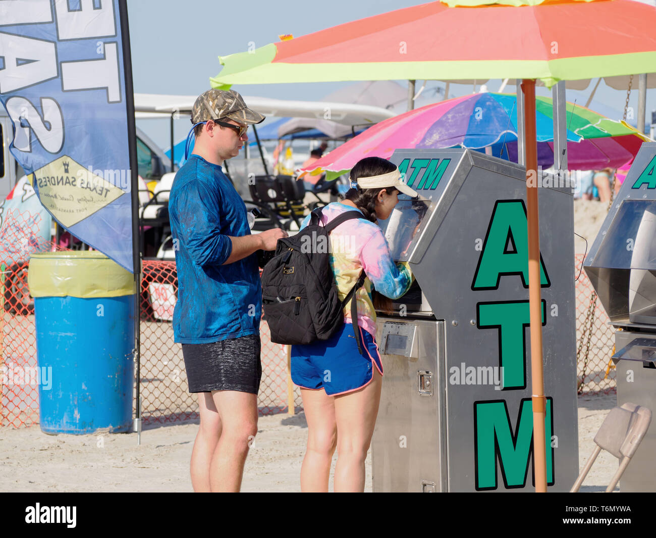Un jeune couple à l'aide d'un guichet automatique au Texas 2019 Sandfest à Port Aransas, Texas USA. Banque D'Images